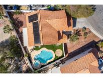Aerial view showcases a pool and spa, solar panels, and a terracotta roof in this well-maintained property at 1011 Pearl Marble Ave, North Las Vegas, NV 89081