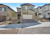 Two-story stucco home features a brick driveway, landscaped yard, and attached two-car garage at 10619 Carnes Ave, Las Vegas, NV 89166