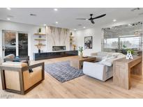 Bright living room with a marble fireplace, sleek ceiling fan and a large window showcasing natural light at 211 Granite Ct, Boulder City, NV 89005