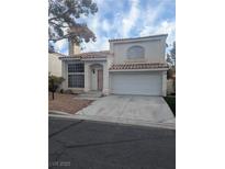 Charming two-story home featuring a tile roof, arched window, attached garage, and low maintenance front yard at 3440 White Mission Dr, Las Vegas, NV 89129