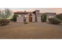 Charming stucco home with a beautiful wooden door and desert landscaping at 519 N Racetrack Rd, Henderson, NV 89015