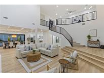 Bright living room boasts an open floor plan, staircase, and sleek modern finishes with lots of natural light at 5225 Villa Dante Ave, Las Vegas, NV 89141