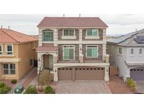 Two-story home featuring a red tile roof, neutral stucco, stone accents, balcony and a two-car garage at 6346 Rock Strm Ln, Las Vegas, NV 89141