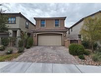 Charming two-story home featuring a brick driveway, well-maintained landscaping, and an attached two-car garage at 8105 Switchback Run St, Las Vegas, NV 89166