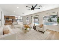 Bright living room features contemporary furnishings, a ceiling fan, and direct access to the backyard pool at 8305 Woodland Prairie Ave, Las Vegas, NV 89129