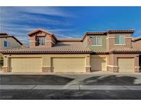 Townhouse complex showcasing garages and tiled roofs against a blue sky at 8324 W Charleston Blvd # 2053, Las Vegas, NV 89117
