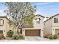 Charming two-story home with desert landscaping and a brown two car garage door at 10574 Siesta Key St, Las Vegas, NV 89141