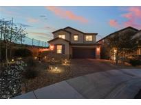 Charming two-story home featuring desert landscaping and a brick driveway at dusk at 176 Brighton Hills Ave, Henderson, NV 89002