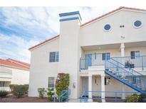 Exterior view of a two story condo with blue accents, a red tile roof, and desert landscaping at 2725 S Nellis Blvd # 2045, Las Vegas, NV 89121