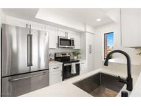 Modern kitchen features stainless steel appliances, white cabinetry and countertops, and black hardware at 2838 Geary Pl # 4002, Las Vegas, NV 89109