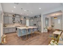 A spacious kitchen featuring grey cabinets, stainless steel appliances, a large island and stylish barstool seating at 10001 Regency Square Ave, Las Vegas, NV 89148