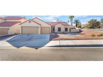 Charming single-story home with a two-car garage, neutral stucco exterior and rock landscaping at 1744 Marshall Dr, Henderson, NV 89014