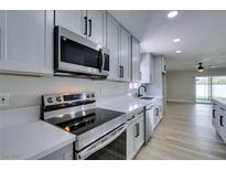 Modern kitchen features stainless steel appliances, white cabinets, and quartz countertops at 5800 Balzar Ave, Las Vegas, NV 89108