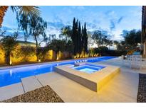 Tranquil backyard pool and spa illuminated against the night sky, perfect for relaxation and outdoor entertaining at 7307 Iron Oak Ave, Las Vegas, NV 89113