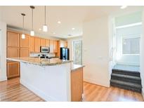 Bright kitchen featuring light wood cabinets, granite countertops, and a convenient breakfast bar at 9050 W Tropicana Ave # 1178, Las Vegas, NV 89147