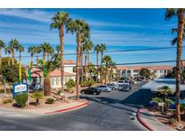 Beautiful condominiums community featuring lush landscaping, a sign, and ample parking at 3318 N Decatur Blvd # 1059, Las Vegas, NV 89130