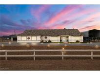 Charming single-story home with beautiful desert landscaping and stunning sunset sky at 1550 Tiptop Trl, Pahrump, NV 89048