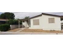 An exterior view of a single-story home featuring a carport and low-maintenance landscaping at 3231 Comitan Ln, Las Vegas, NV 89122