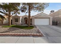 Charming single-story home featuring desert landscaping, a two-car garage, and a red tile roof at 3519 Greenwick Dr, North Las Vegas, NV 89032