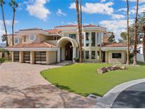 Stunning home with a beautiful lawn, large windows, and a spacious three-car garage at 42 Sawgrass Ct, Las Vegas, NV 89113
