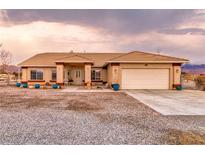 Charming single-story home featuring a two-car garage, desert landscaping and covered entryway at 620 W Leffner Dr, Pahrump, NV 89060