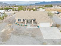Expansive single-story home with a neutral color palette, covered porch, and desert landscaping at 620 W Leffner Dr, Pahrump, NV 89060