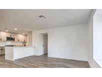 Open-concept living space featuring wood floors and a modern kitchen with stainless steel appliances at 6741 W Charleston Blvd # 1, Las Vegas, NV 89146