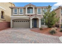 Charming two-story home featuring a brick driveway, desert landscaping, and a welcoming entrance with a covered porch at 8176 Duncan Peak Ct, Las Vegas, NV 89139