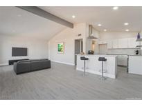 Open concept living space featuring recessed lighting, beamed ceilings, and bar seating at the kitchen counter at 1720 Hassett Ave, Las Vegas, NV 89104