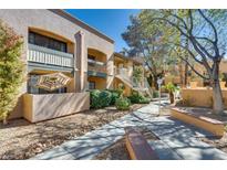 Beautiful condo community featuring landscaped grounds, walkways, and charming exterior architecture at 5138 S Jones Blvd # 207, Las Vegas, NV 89118