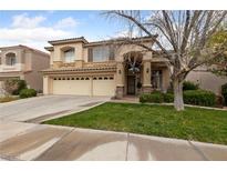 Charming two-story home featuring a spacious three-car garage and well-manicured front yard at 10 Staghorn St, Henderson, NV 89012