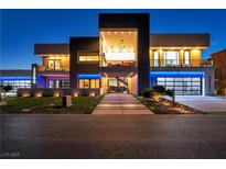 Striking contemporary home showcasing modern design, landscape lighting, and a unique car display feature at 3266 S Spring Mountain Blvd, Pahrump, NV 89048
