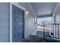 View of blue-painted front door with a brushed gold door number, at unit 203, on a covered landing at 5345 Silvermist Ct # 203, Las Vegas, NV 89122