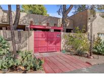 Unique gated entrance with red double doors and desert landscaping at 5785 N Tee Pee Ln, Las Vegas, NV 89149