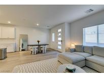 Bright living room featuring modern decor, wood-look floors, a large couch, and a contemporary dining area at 600 N Carriage Hill Dr # 1020, Las Vegas, NV 89138