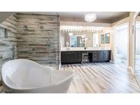 Luxurious bathroom with a soaking tub, double vanity, and a large glass shower with elegant, wood-like tiling at 8100 Lake Hills Dr, Las Vegas, NV 89128