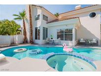Inviting pool with a spa, flamingo float, and outdoor seating, creating a relaxing backyard oasis at 8100 Lake Hills Dr, Las Vegas, NV 89128