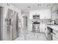 Modern kitchen with stainless steel appliances and white cabinets at 1216 Padre Serra Ln, Las Vegas, NV 89134