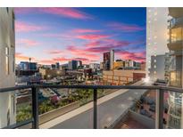 Balcony view of a vibrant cityscape with colorful sunset skies, glass railings, and nearby buildings in clear view at 150 Las Vegas Blvd # 1014, Las Vegas, NV 89101
