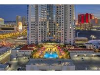 Luxury high-rise building featuring a pool with city views and a landscaped lounge area at dusk at 200 W Sahara Ave # 801, Las Vegas, NV 89102