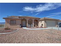 Charming single-story home with desert landscaping, covered porch, and a two-car attached garage at 2300 S Washoe Ave, Pahrump, NV 89048