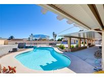 Inviting backyard pool with covered patio, lounge area, and well-maintained landscaping offers a private oasis at 3070 Breton Dr, Las Vegas, NV 89108