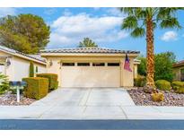 Beige home with a two-car garage, neutral landscaping, and a palm tree with American flag on a sunny day at 4496 Largo Cantata St, Las Vegas, NV 89135