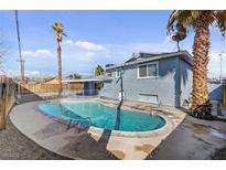 Backyard view featuring a pool and large palm trees for an outdoor oasis at 6121 Edgewood Cir, Las Vegas, NV 89107