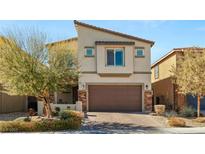 Inviting two-story home featuring a brown two-car garage, stone accents, and manicured landscaping at 7717 Rosebark Cliffs St, North Las Vegas, NV 89084