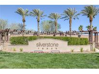 Silverstone Ranch community entrance with mature palm trees, lush landscaping, and a decorative pergola at 8645 Deering Bay Dr, Las Vegas, NV 89131
