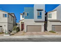 Modern home exterior showcasing a two-car garage, red door, and contemporary architectural details at 3354 Via Strada St, Henderson, NV 89044