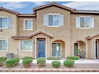 Charming townhome featuring a blue front door, light shutters, and inviting curb appeal at 8520 Insignia Ave # 104, Las Vegas, NV 89178