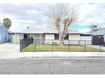 Charming single-story home featuring a fenced front yard with low maintenance landscaping and a gray exterior at 1021 Wengert Ave, Las Vegas, NV 89104