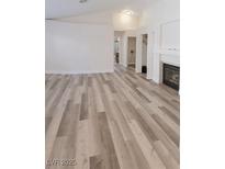 Bright living room features wood-look floors, a fireplace, and white walls creating a welcoming space at 1624 N Torrey Pines Dr # 101, Las Vegas, NV 89108